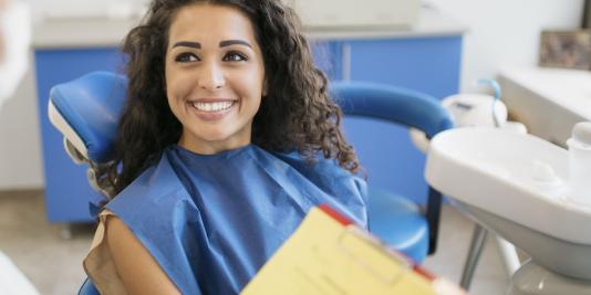 Young female patient consults with dental hygienist in dental office