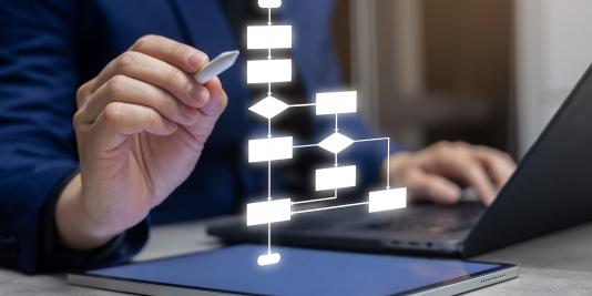 Researcher's hand with stylus points at a flow chart diagram hologram.